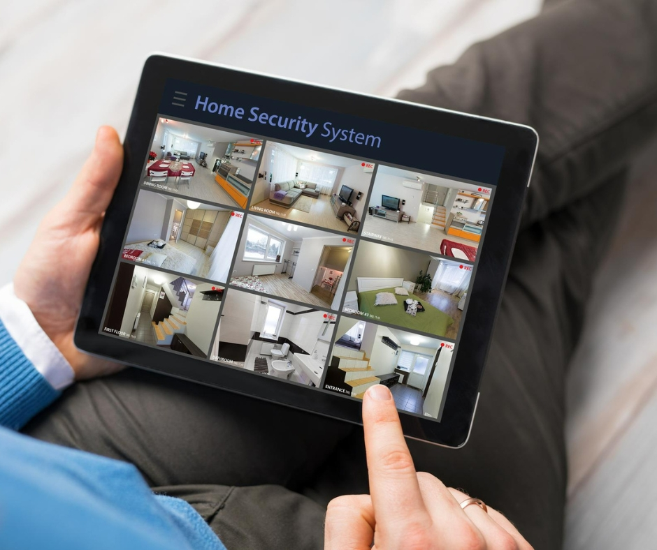 A man looking at home security cameras tablet with a smart home setup